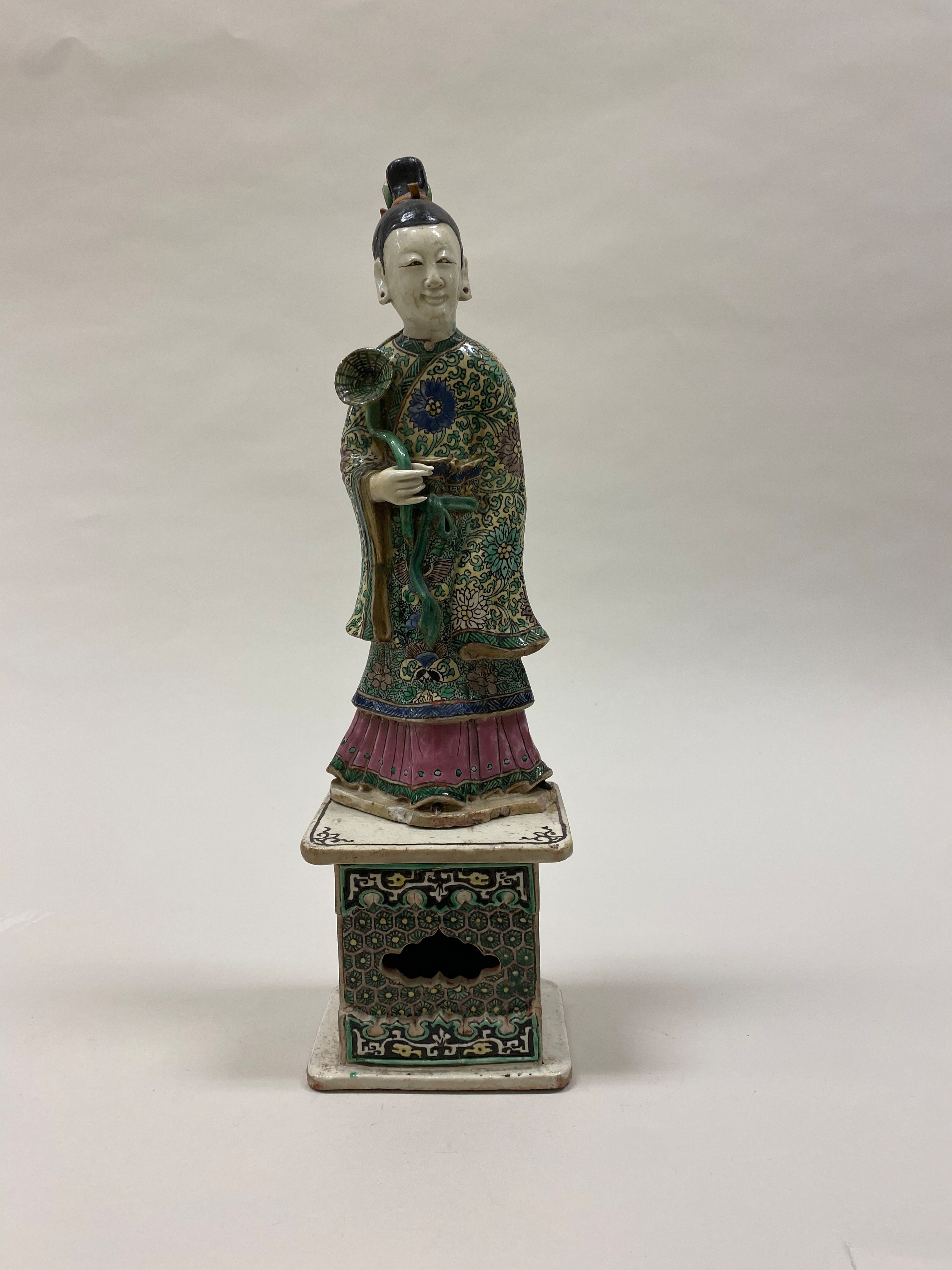 Polychrome ceramic figure of He Xiangu standing in flowing robes.