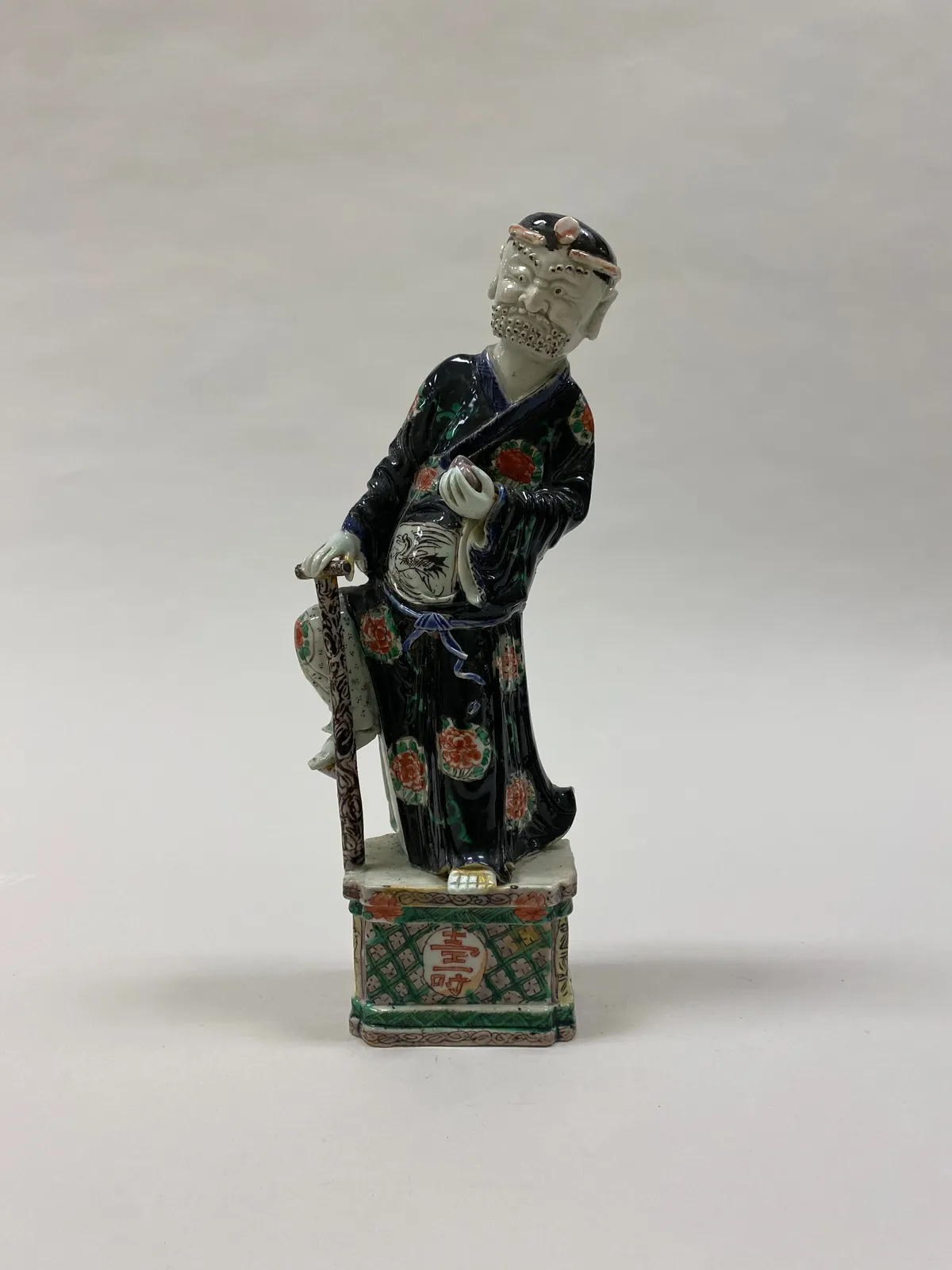 Polychrome ceramic figure of Li Tieguai carrying his crutch and gourd.