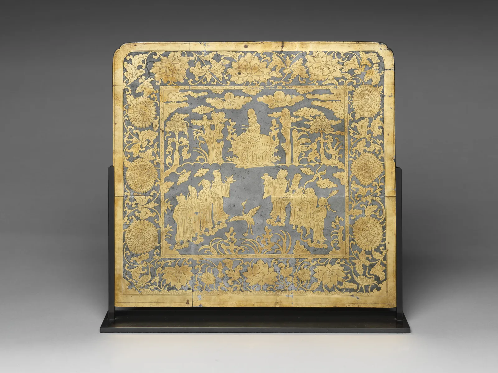 Metal table screen decorated with immortals in a landscape scene.